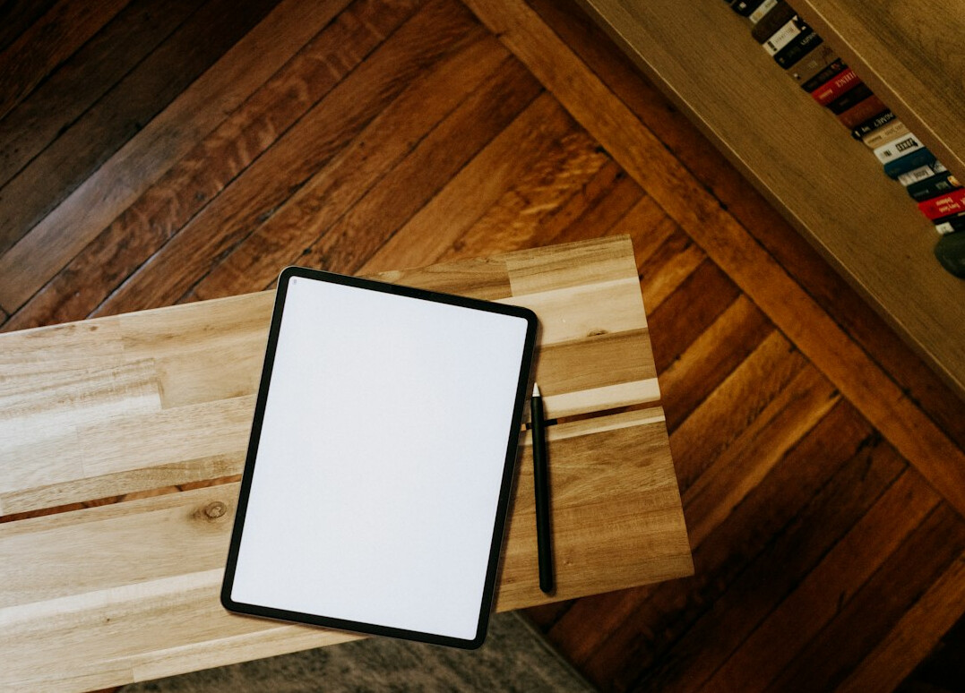Hands reviewing insurance documents next to a tablet on a desk